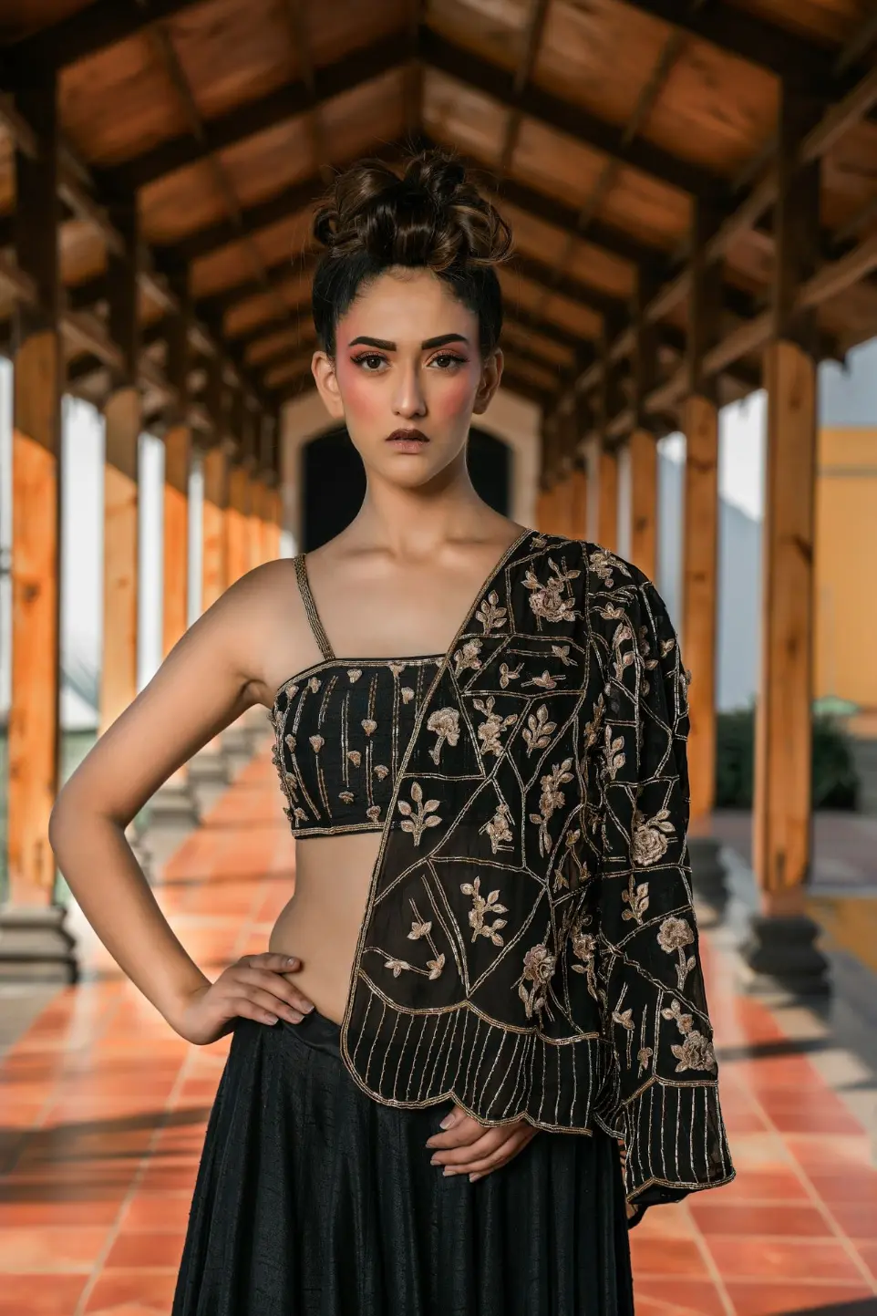 Woman in ornate black outfit with dramatic makeup